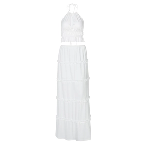 Detail view of white two-piece set featuring halter crop top and ruffled tiered maxi skirt