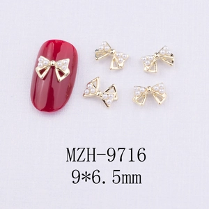 Vue détaillée de 5 bijoux d'ongles nœuds dorés avec perles et mesure de 9x6,5mm
