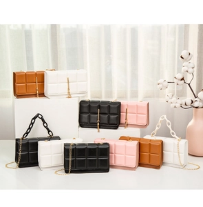 Close-up of quilted square bags in black, white, brown and pink with golden tassels