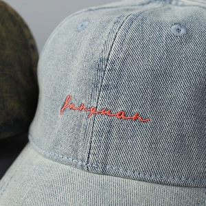 Light blue washed denim baseball cap with red script embroidery and soft top style