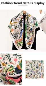 Makro-Detail des Seidenquadrats mit bunten Vogel- und Blumen-Illustrationen auf dem Tuch