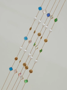 Macro shot of long cat eye stone and pearl handmade beaded necklaces in gold finish