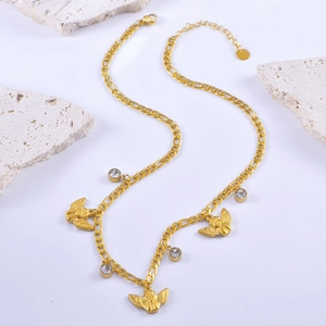 Golden angel pendant necklace with round zircon and figaro chain on white stones