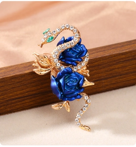 Macro detail of a golden snake brooch with blue roses and sparkling rhinestones