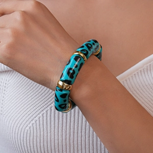 Close-up of blue leopard print acrylic beaded bracelet with gold spacers on wrist