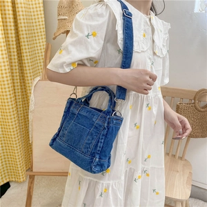 Minimalist blue denim crossbody bag worn by a model in a casual indoor setting
