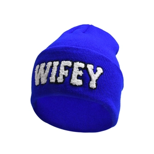 Detail of blue knitted beanie featuring white fuzzy WIFEY embroidery and ribbed texture