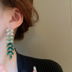 Detail of leaf tassel earrings with green gradient crystals and golden alloy fringe