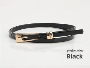 Detail of slim black patent leather belt for women with elegant gold pin buckle