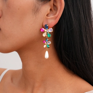 Close-up of elegant flower earrings with colorful gems and a single white pearl drop
