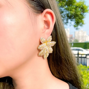 Detailed view of luxury gold leaf earring with micro-paved cubic zirconia stones
