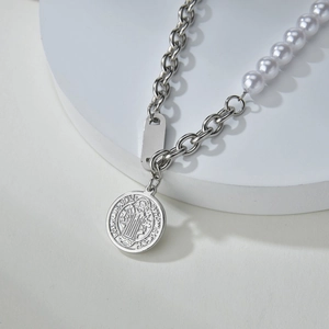Collier en acier titane rétro avec perles et médaille de Saint Benoît sur un socle