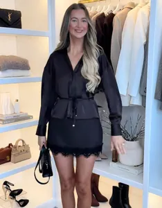 Dettaglio di un top in raso nero elegante con texture setosa e design sfiancato