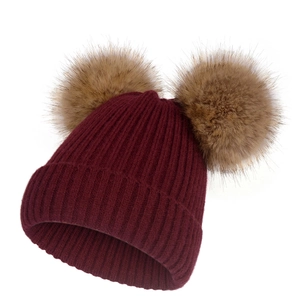Bonnet en tricot bordeaux pour l'hiver avec deux pompons en fausse fourrure marron