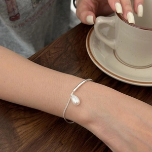 Detail of S925 sterling silver pearl bracelet on wrist with elegant minimalist design