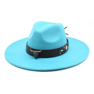 Detail of bright turquoise fedora hat with bull head emblem and embroidered floral accents