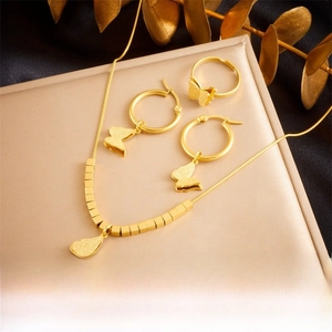 Detail view of gold butterfly jewelry set featuring frosted necklace, ring, and earrings