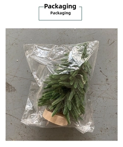 Miniature artificial Christmas tree with wood base in protective plastic packaging