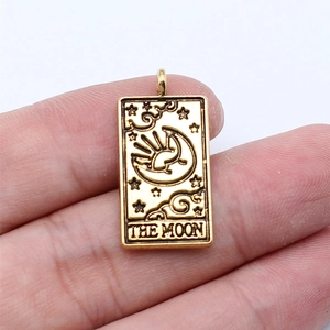 Detailed view of a gold tarot moon pendant featuring stars and clouds on a rectangle base