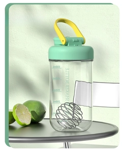 Close-up of green 750ml protein shaker bottle with scale markings and mixing ball