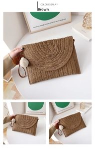 Detail of a brown woven straw clutch bag with colorful pom-poms and leather wrist strap