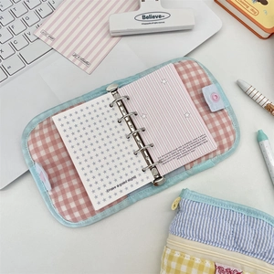 Detailed view of pink plaid quilted fabric binder notebook with 6-ring metal mechanism