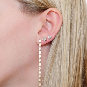 Detailed view of rhinestone tassel earrings and ball studs on model with blonde hair