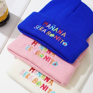 Detail of colorful embroidery and thick knit texture on multi-color winter beanies