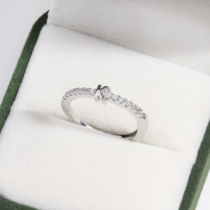 Detail of silver letter K ring with diamonds in a premium green velvet jewelry box