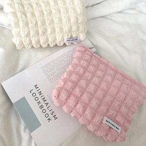 Quilted candy color bubble makeup bags in pink and cream on soft white fabric