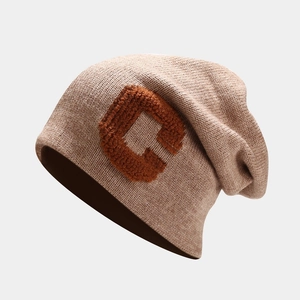 Detail of oatmeal knit beanie with orange chenille letter C patch and soft ribbed texture