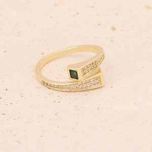 Macro view of adjustable gold crown ring with green emerald-cut stone and white zircon pave