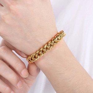 Close-up of a 18k gold-plated wheat link chain bracelet worn on a man's wrist