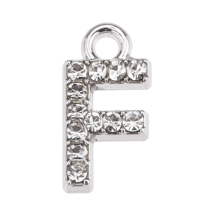 Macro shot of silver letter F pendant with clear zircon inlay and top hanging ring