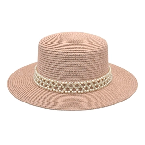 Detailed macro view of woven texture and pearl trim on pink boater hat