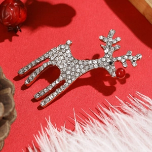 Détail d'une broche renne argentée avec strass sur un fond festif rouge vif