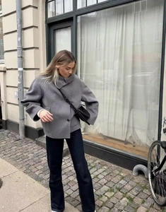 Outdoor street view of a grey cropped wool coat with single-breasted buttons and jeans