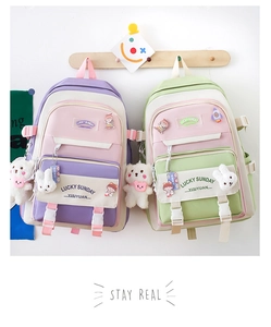 Detail of Korean style school backpacks with cute plush bear and bunny charms on pockets