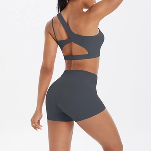 Detail of dark gray one-shoulder yoga bra and high waist shorts set on model
