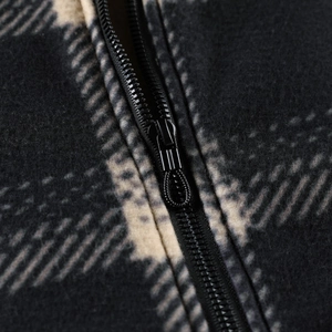 Macro detail of high-quality zipper and black checkered fleece texture on hoodie