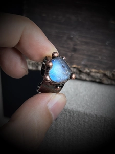 Macro shot of handmade vintage bronze ring with heart-shaped blue moonstone detail