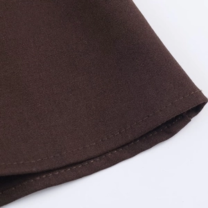 Close-up of fine double-stitched hem on dark brown woven dress fabric