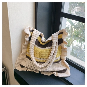 Detail of striped crochet tote bag with ruffle trim on a windowsill in natural light
