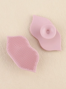 Detailed view of pink lip-shaped silicone exfoliating brush with suction cup handle