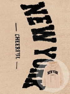 Detail of plush lamb wool fabric and embroidered New York lettering on beige hoodie