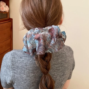 Detailed back view of a high elastic scrunchie with abstract ink pattern on a braided ponytail