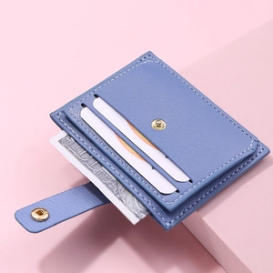 Detail of blue slim card holder with multiple slots and metal snap closure on pink background