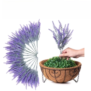 Detail of purple artificial lavender being placed into a hanging coconut liner basket