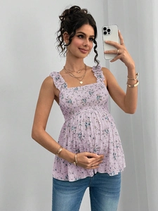 Détail d'un haut de maternité lilas à fleurs avec bretelles à volants et smocks