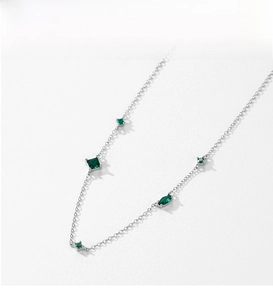 Macro shot of S925 silver necklace with emerald-green square and marquise zircons
